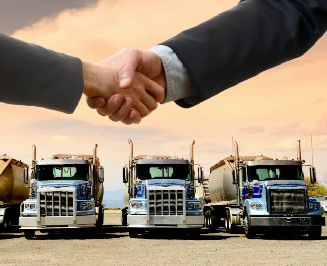 Handshake in front of trucks